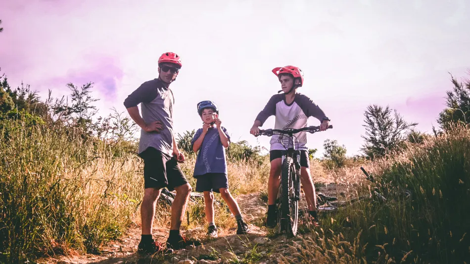 ein Mann mit 2 Kindern in der Natur beim Fahrradfahren - wichtig ist die Körpergrösse bei Kinderfahrrädern